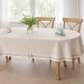 ekspozycja obrusu beżowego plamoodpornego z dwukolorową koronką i kokardką na owalnym stole
